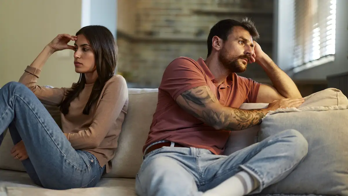Fremdgehen Symbolbild: streitendes Paar sitzt mit dem Rücken zueinander
