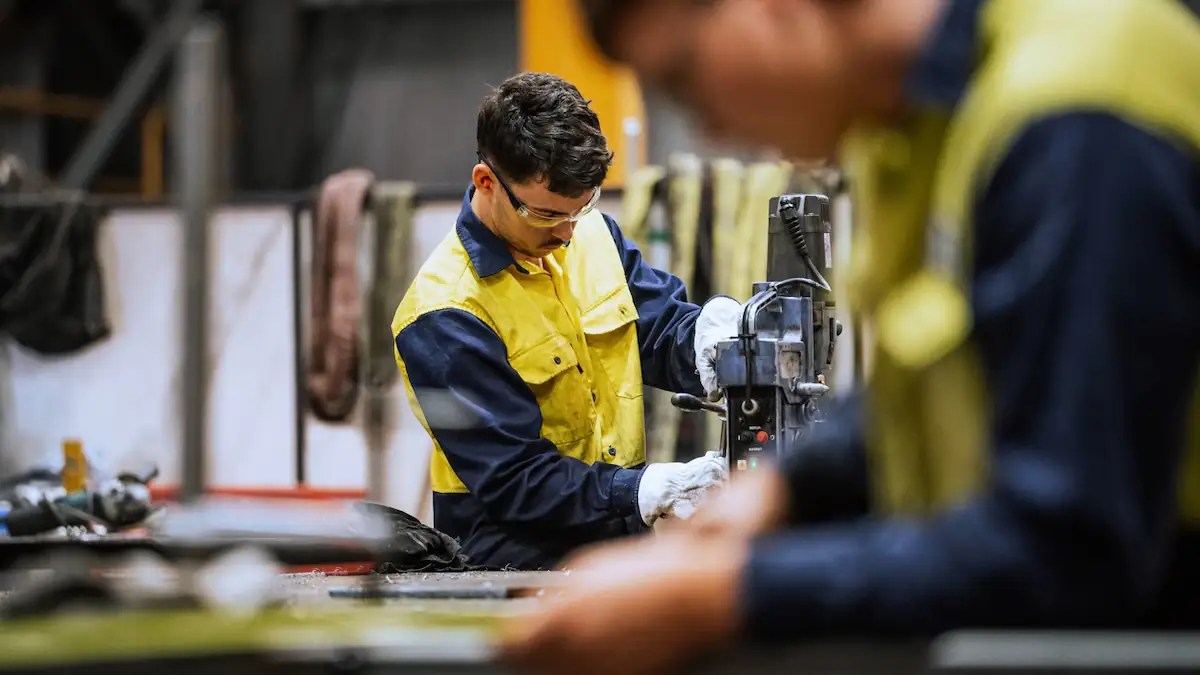 Arbeitszeit Symbolbild: junger Mann arbeitet in Stahl-Unternehmen