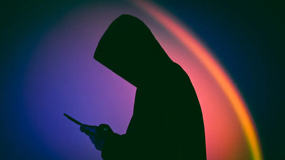 Smartphone-Überwachung Symbolbild: dunkle Kapuzengestalt schaut auf ein Handy