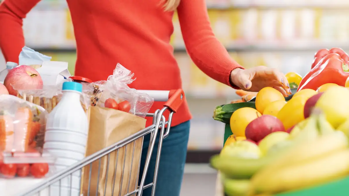 Inflationsrate Symbolbild: Frau kauft frische Lebensmittel im Supermarkt mit Einkaufswagen