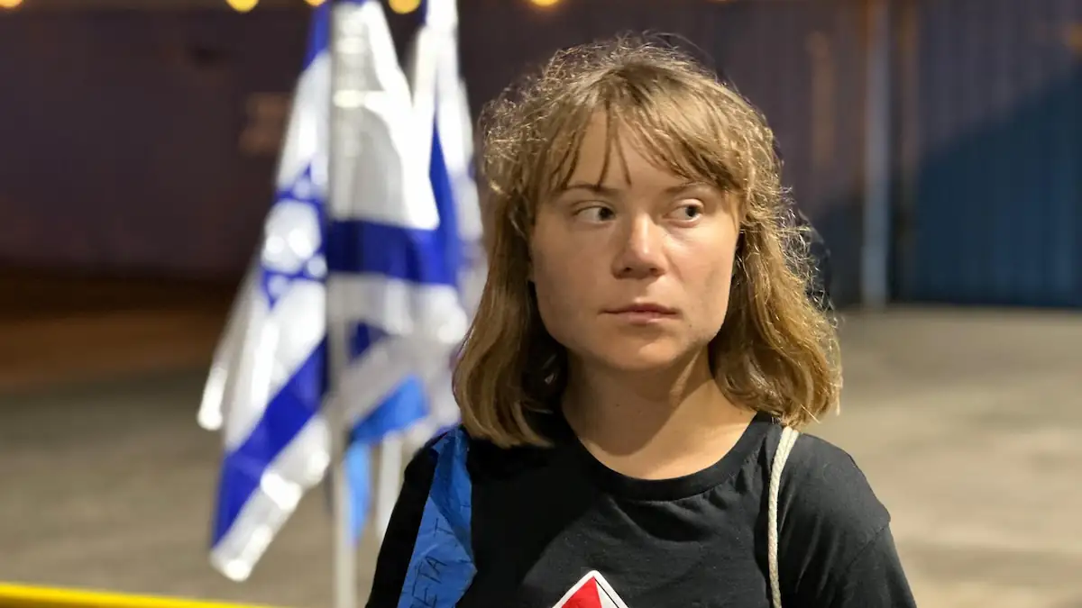Greta Thunberg in dunklem Pullover vor Israel-Flagge während Rückreise nach Schweden