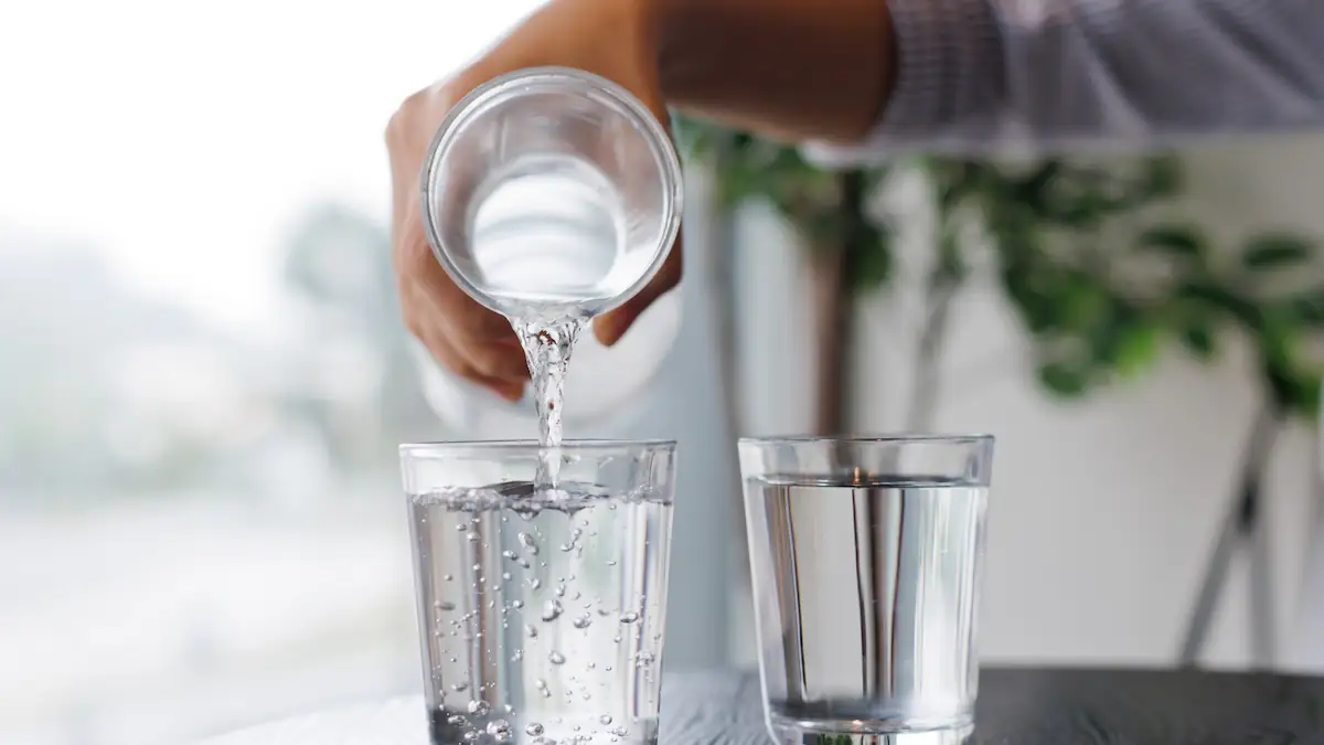 Wassertest bei Bewerbungen: Jemand gießt Wasser aus einer Karaffe in zwei Gläser