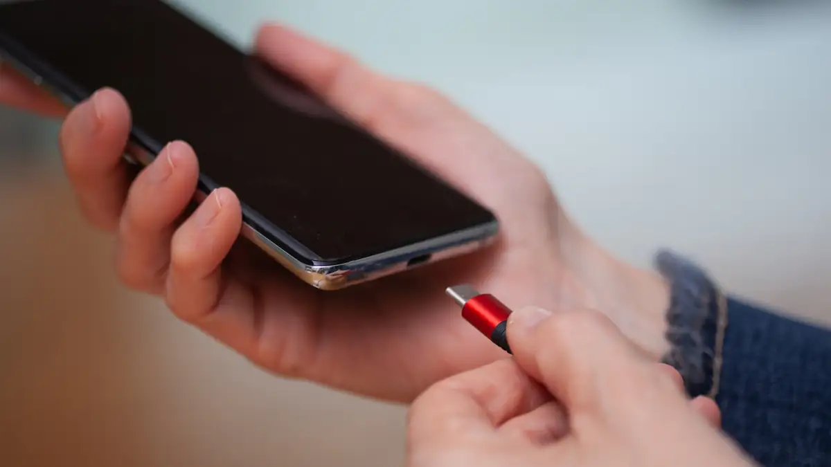 Akku aufladen: Rot-schwarzes Ladekabel mit USB-C wird in Smartphone gesteckt