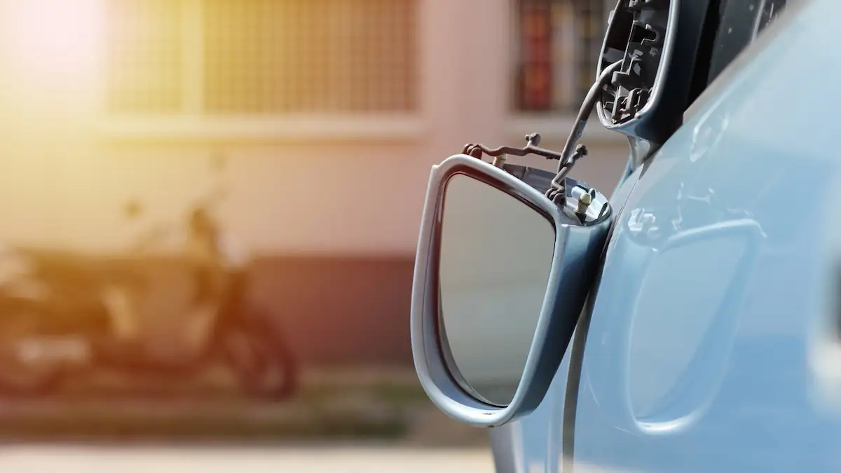 Spiegeltrick: kaputter Seitenspiegel hängt an blauem Auto
