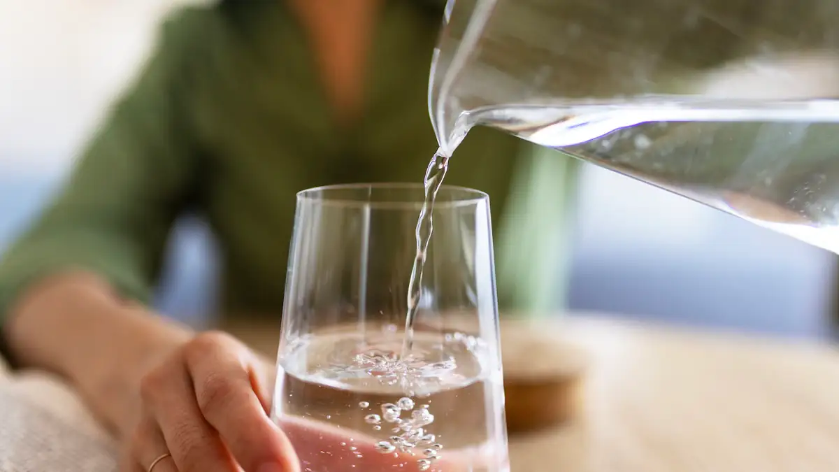 Wassertest: Jemand schenkt Wasser in ein Glas ein