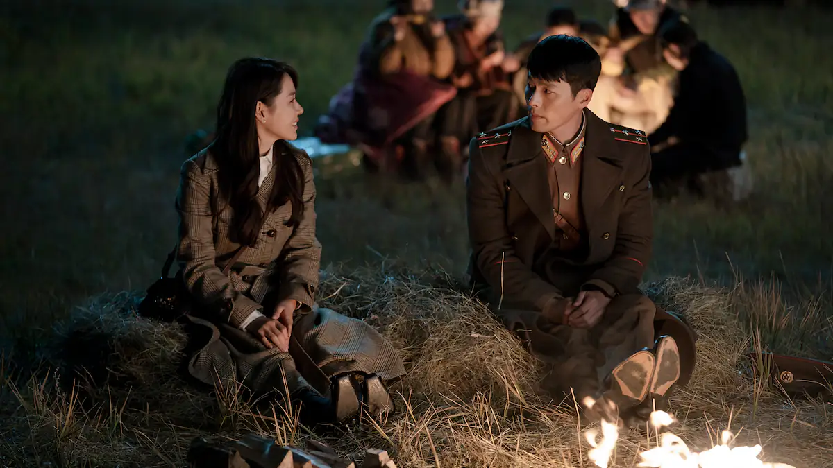 Szene aus Crush Landing On You: Yoon Se-ri und Ri Jeong-hyeok sitzen am Lagerfeuer