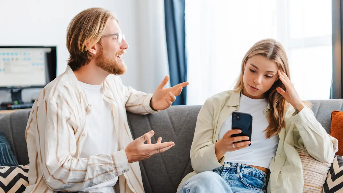 Unsympathisch: Mann redet auf Frau ein, die auf ihr Handy schaut