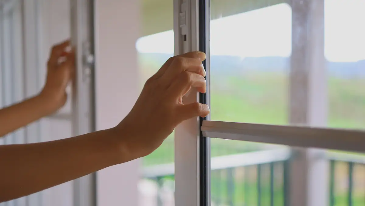 Frau macht Fenster auf zum Lüften