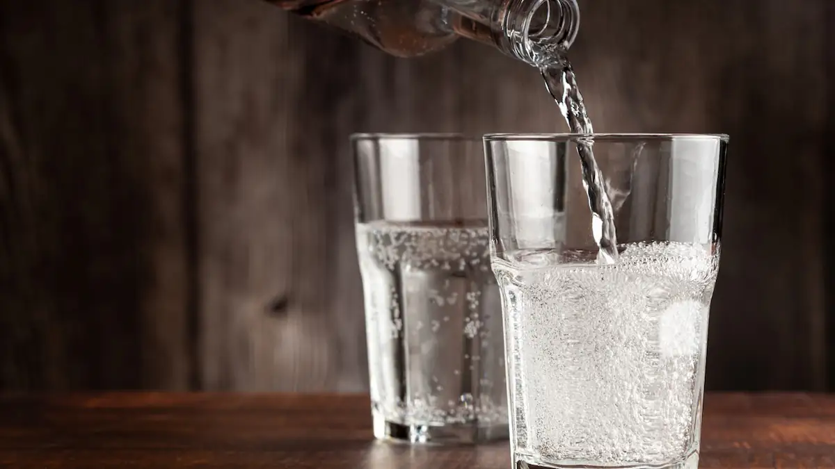 Wasser wird in zwei Gläser eingeschenkt