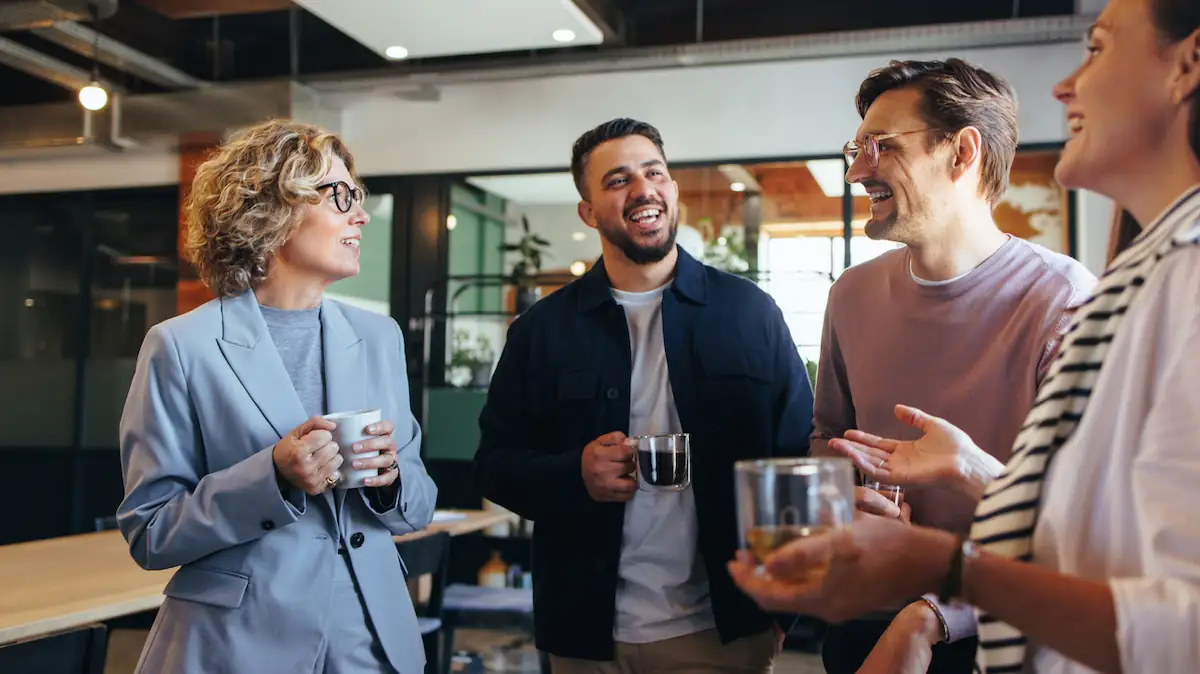 Small Talk: Kollegen machen Kaffeepause und reden lächelnd miteinander