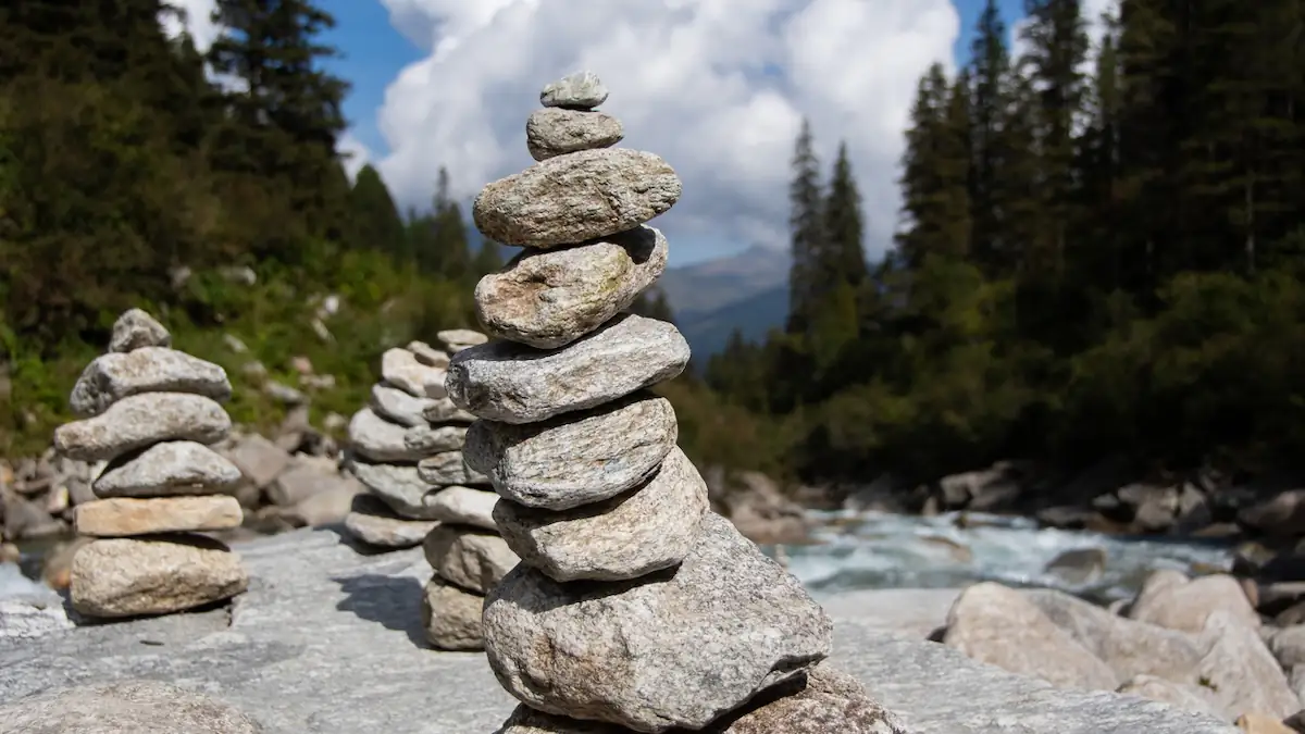 Mehrere Steintürme dicht beieinander vor Berglandschaft