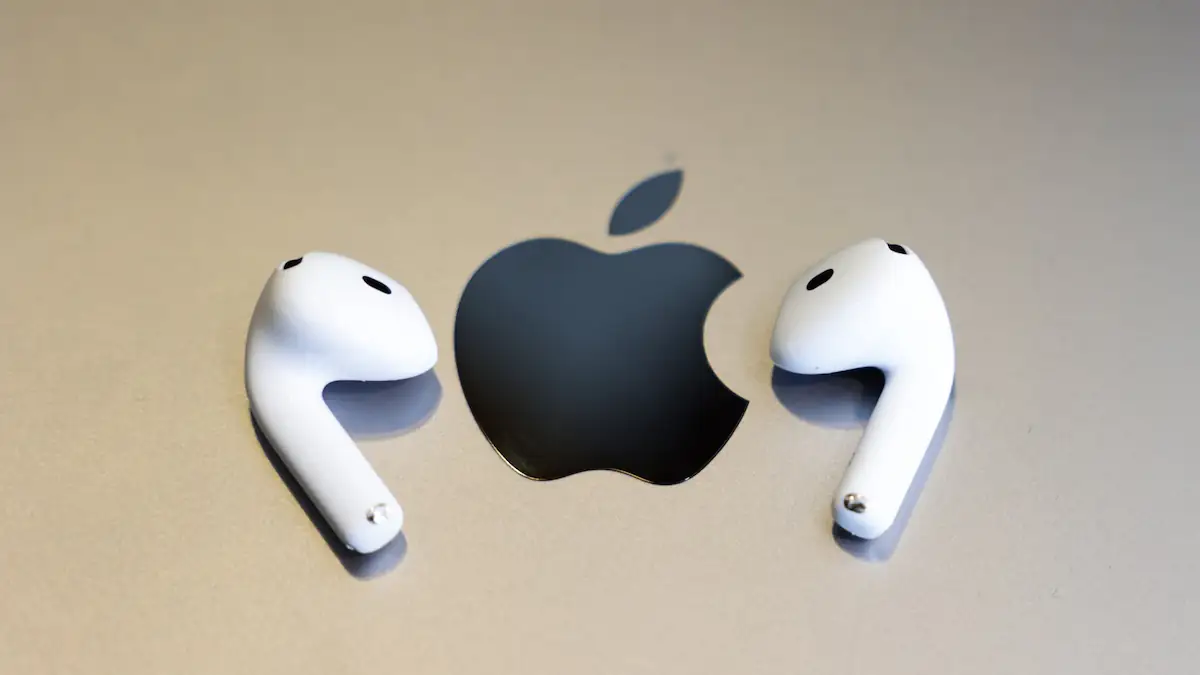 AirPods 4 liegen einzeln neben einem Apple-Logo