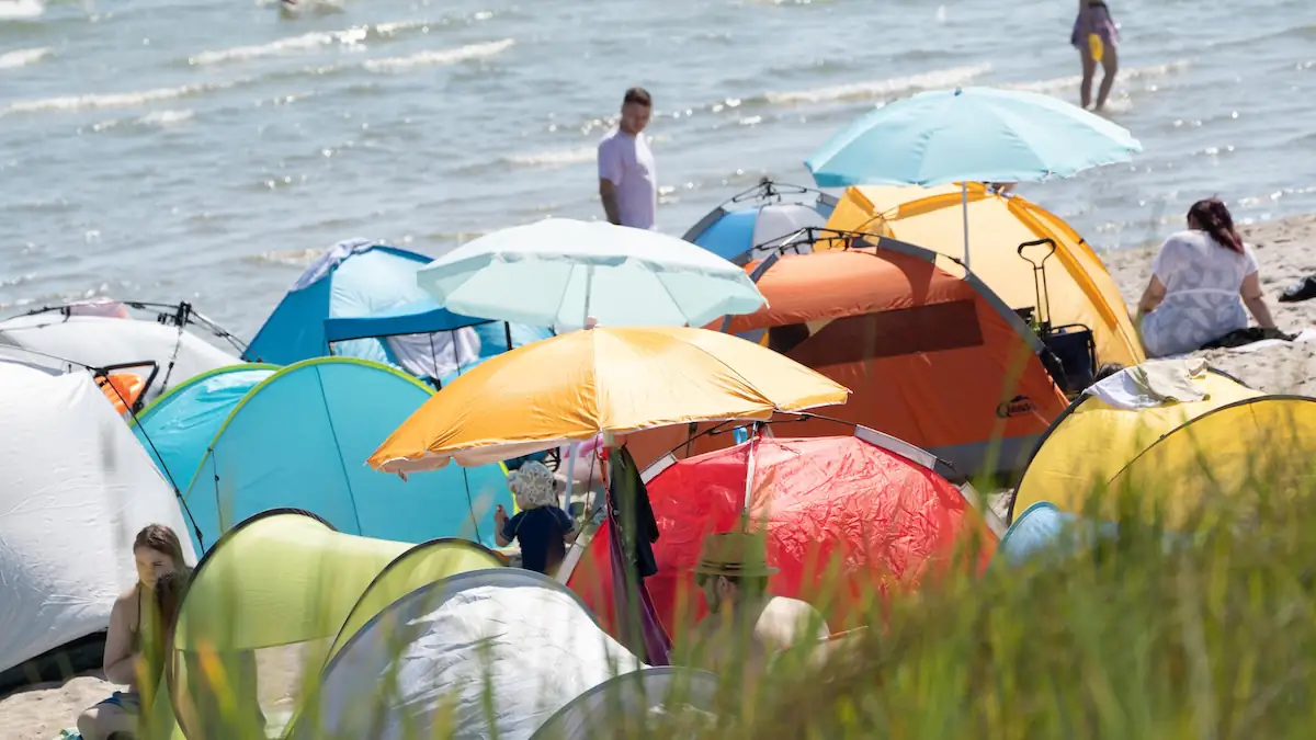 Beach Sprawling: Überfüllter Strand voller Sonnenschirme, Zelte und Menschen