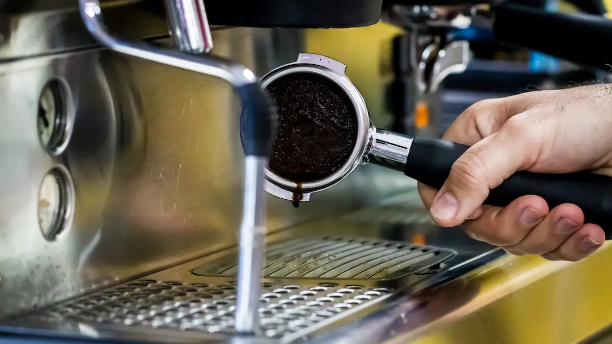 Nahaufnahme Siebhalter einer Espressomaschine mit Kaffeesatz, den man noch zum Grillen benutzen kann
