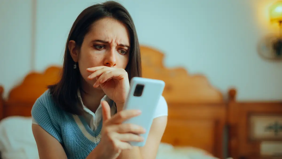 Ostsee Abzocke Symbolbild: Frau schaut verwirrt und fassungslos auf ihr Smartphone