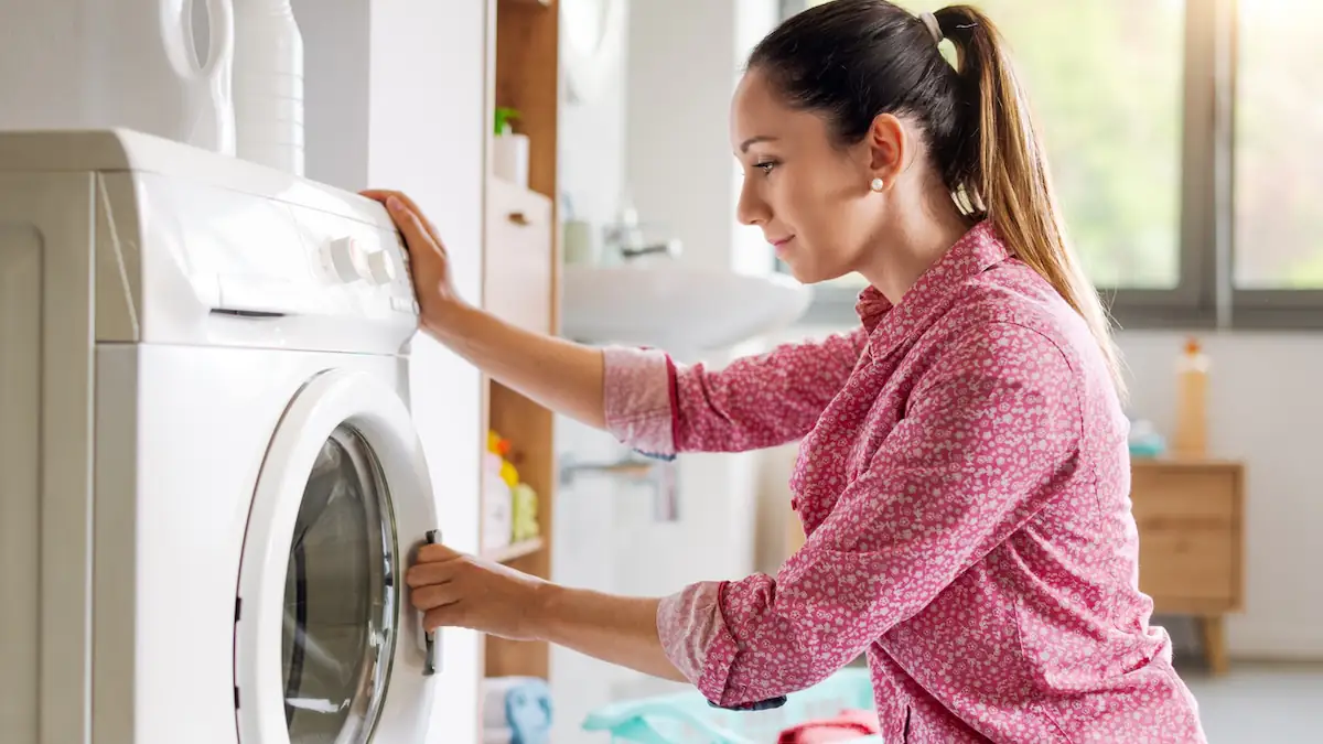 Frau schließt eine Waschmaschine