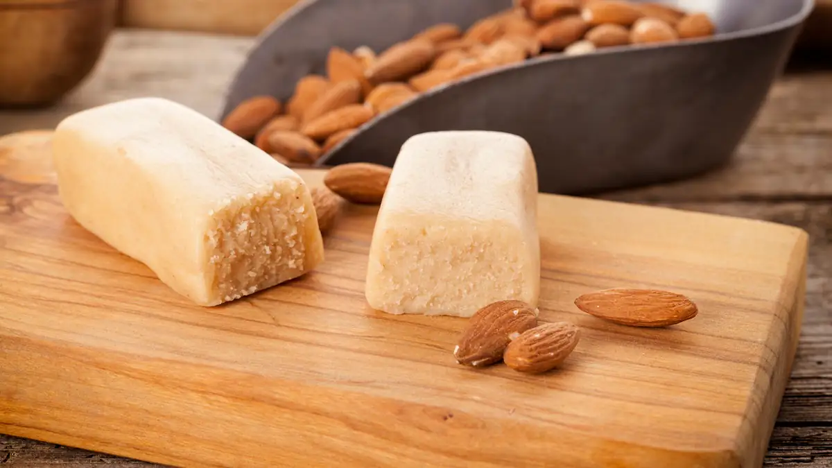 Alkohol in Lebensmitteln: Ein aufgeschnittener Block Marzipan neben ein paar Mandeln
