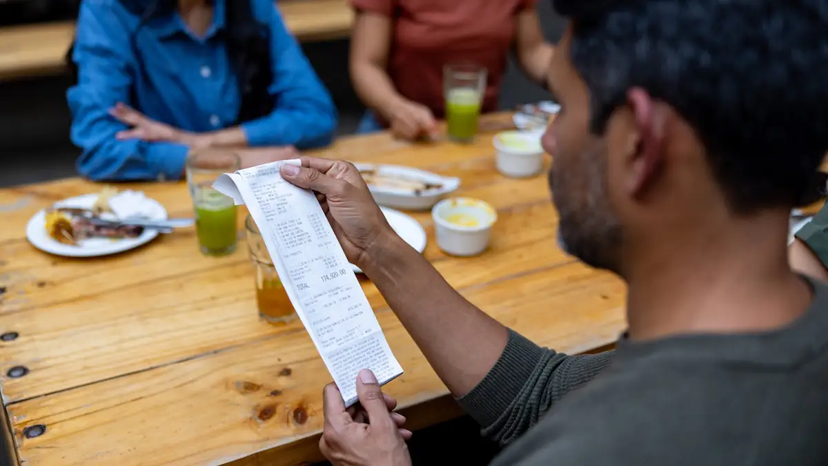 Ein Mann mit dunklen Haaren überprüft im Restaurant seine Rechnung