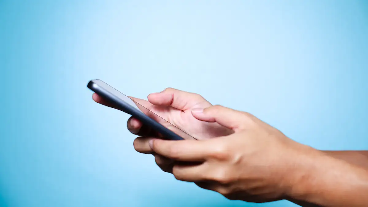 Smartphone, das mit beiden Händen gehalten wird, um es mit den Daumen zu bedienen