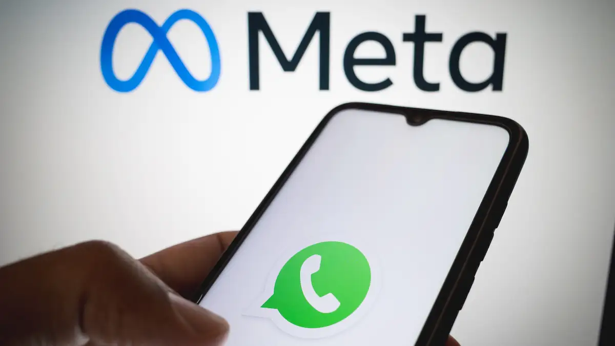 WhatsApp-Logo auf Smartphone, im Hintergrund ein Meta-Schriftzug
