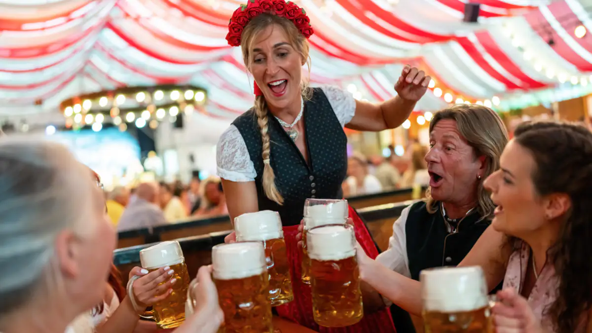 Auf der Wiesn: Mehrere Personen stoßen beim Oktoberfest mit Bier an