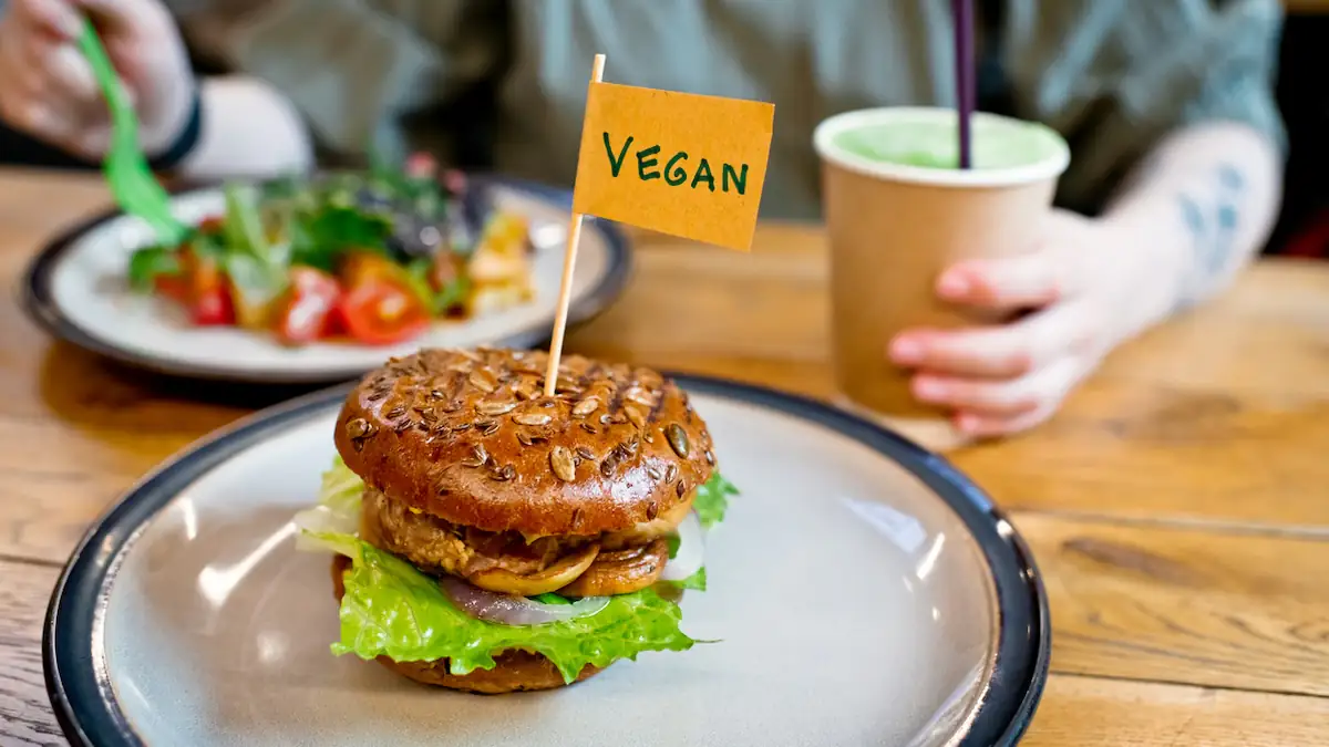 Veganer Burger mit Fleischersatz-Produkt und kennzeichnendem Schild