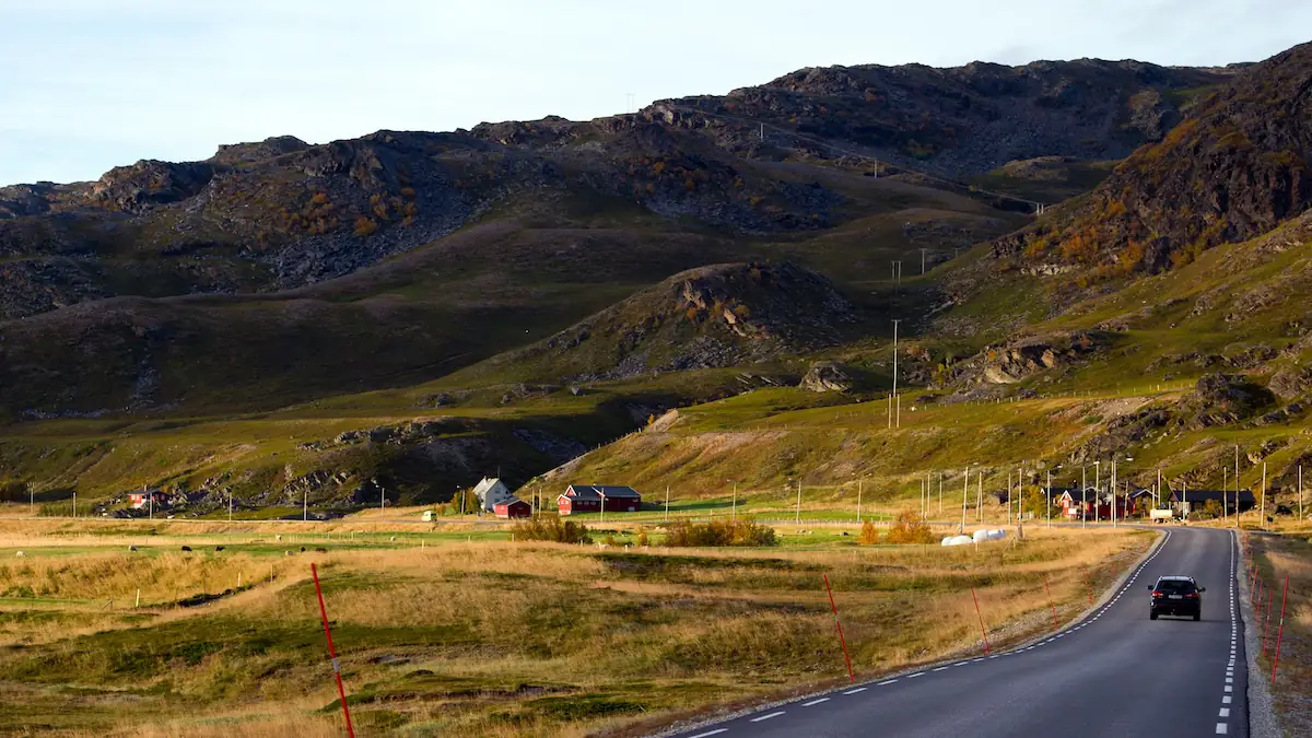 Straße bei Kokelv in Norwegen am Fjord, auf der ein Auto fährt