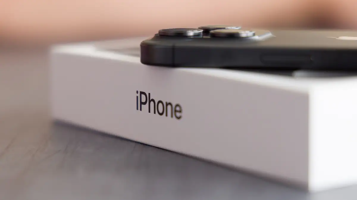 Schwarzes iPhone liegt auf einer Verpackung mit dem Schriftzug „iPhone“