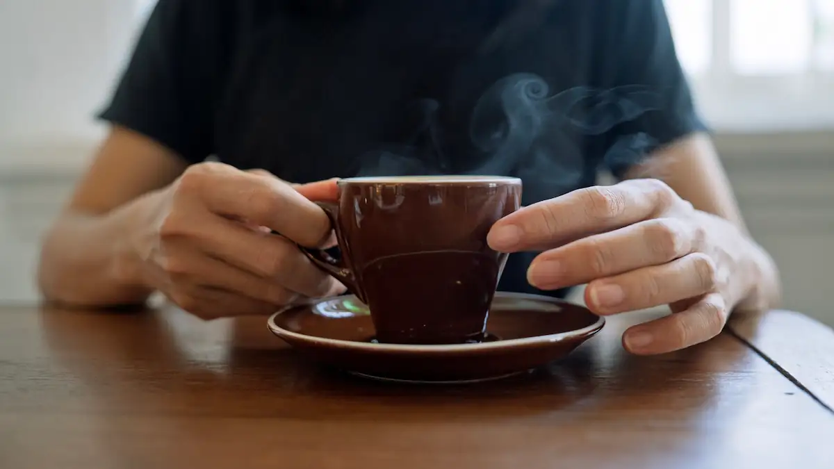 Krebsrisiko heiße Getränke: Jemand hält eine dampfende Tasse mit einem Getränk in der Hand