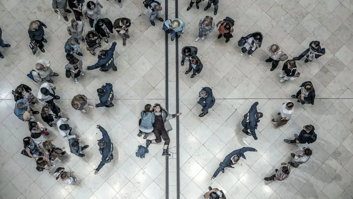 „Absentia“ bei Netflix: Szene aus der Krimi-Serie, die einen Kreis von menschen von oben zeigt, in der Mitte liegt eine verletzte Frau