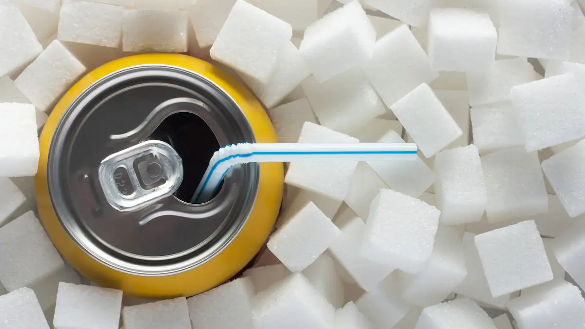 Softdrink beeinflussen Fruchtbarkeit: Getränkedose mit Strohhalm zwischen lauter Zuckerwürfeln