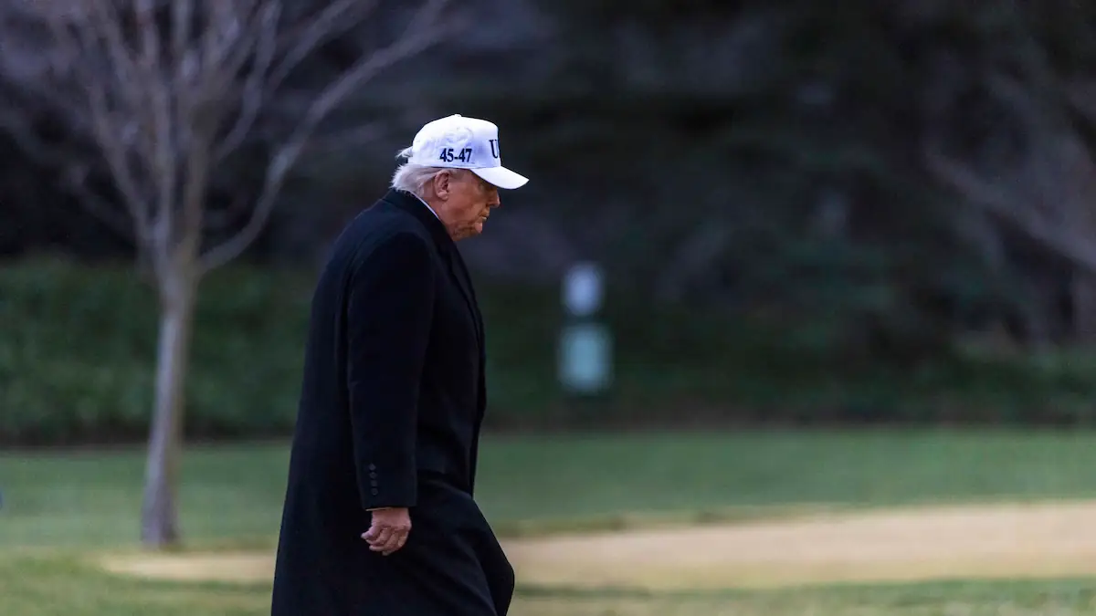 Donald Trump mit weißem Cap und schwarzem Mantel