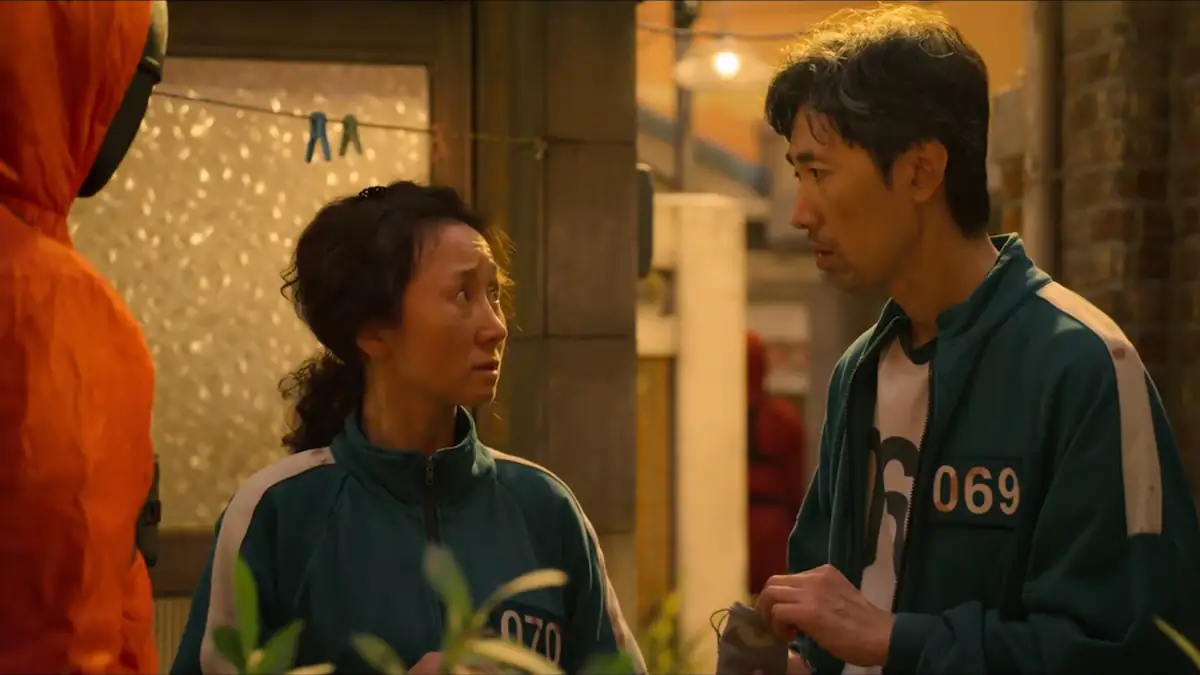 Szene aus „Squid Game“, in der Spieler 069 und 070 sich anschauen