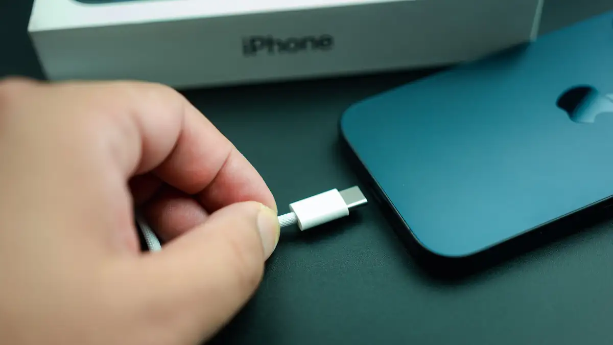 Jemand steckt ein USB-C-Kabel in ein dunkles iPhone 17 Pro