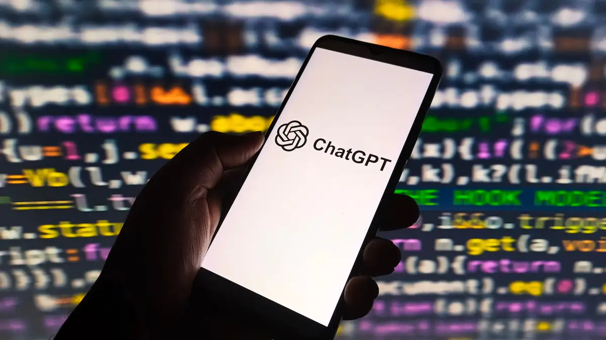 ChatGPT auf einem Smartphone vor HTML-Code