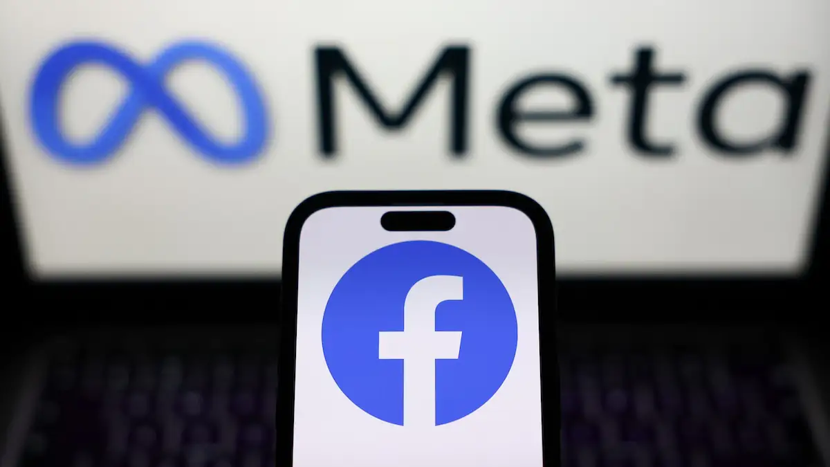 Facebook-Logo auf Smartphone, dahinter das Meta-Logo