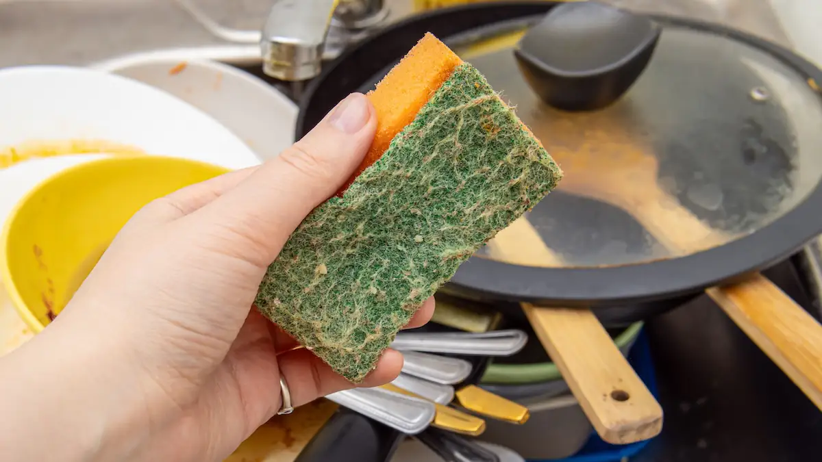 Dreckiger Küchenschwamm mit Geschirr