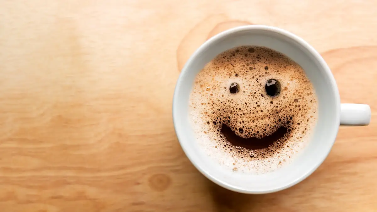 Lächelndes Gesicht wurde in den Schaum eines Kaffees gemalt
