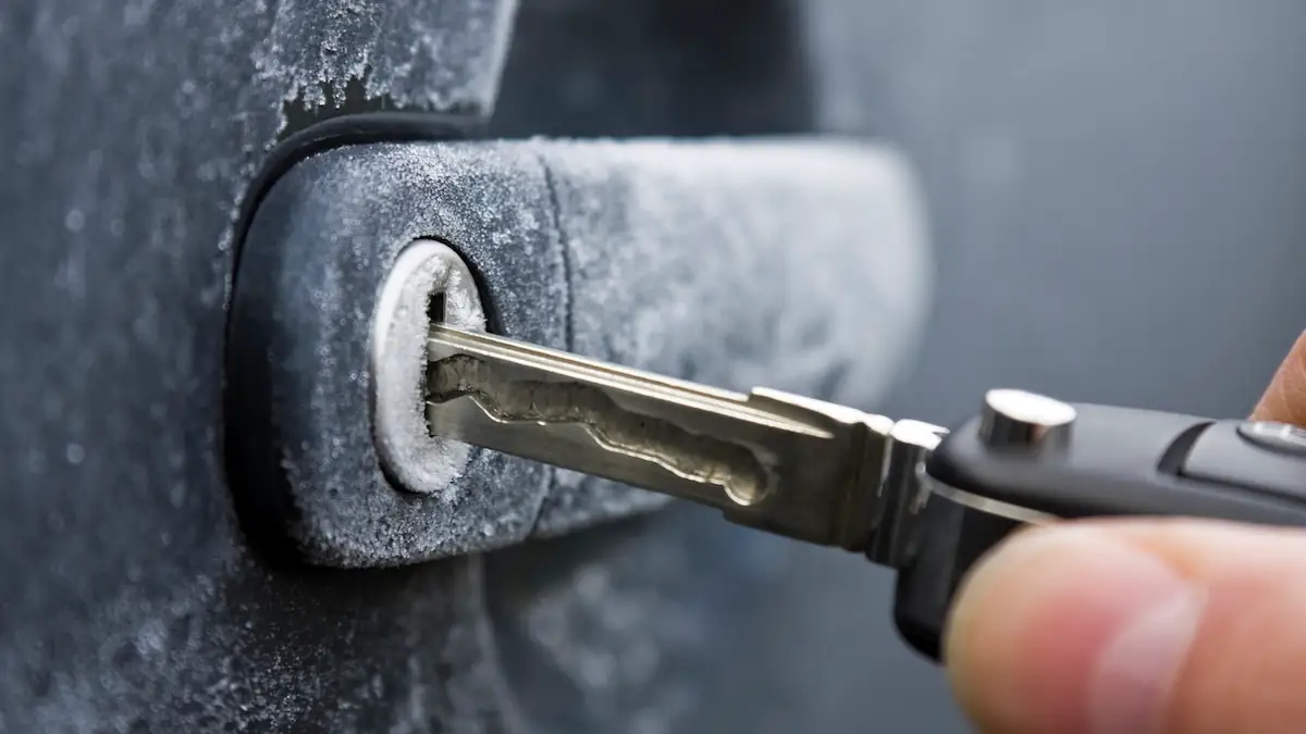 Jemand steckt bei Kälte einen Autoschlüssel ins Schloss