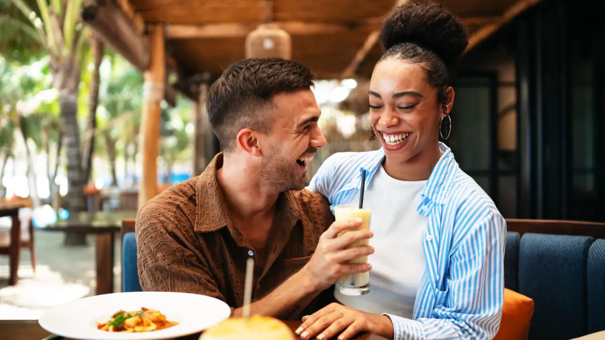 777-Regel: Glückliches Paar lacht beim Essen