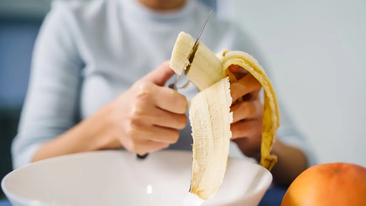 Frau schneidet Banane