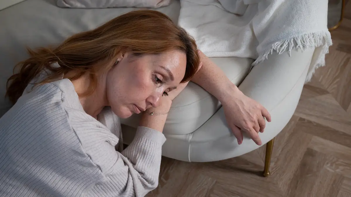 Doomscrolling: Frau sitzt traurig auf dem Boden