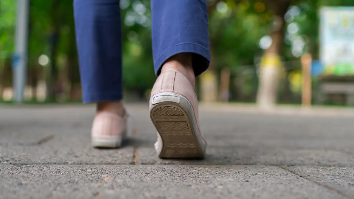 Frau läuft in Turnschuhen über Betonboden, man sieht nur ihre Füße