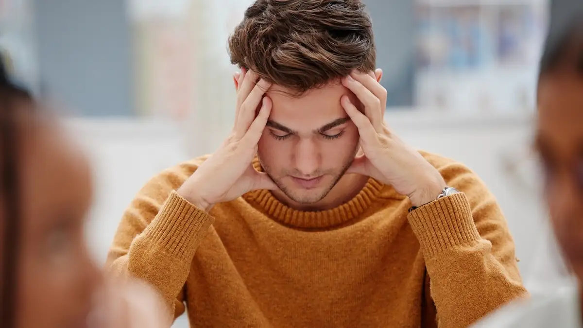 Hirntumor: Junge Mann hält sich wegen SChmerzen den Kopf