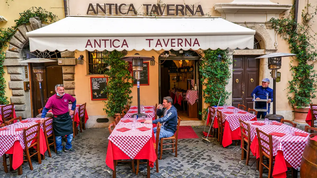 Italienische Taverna mit gedeckten Tischen unter freiem Himmel