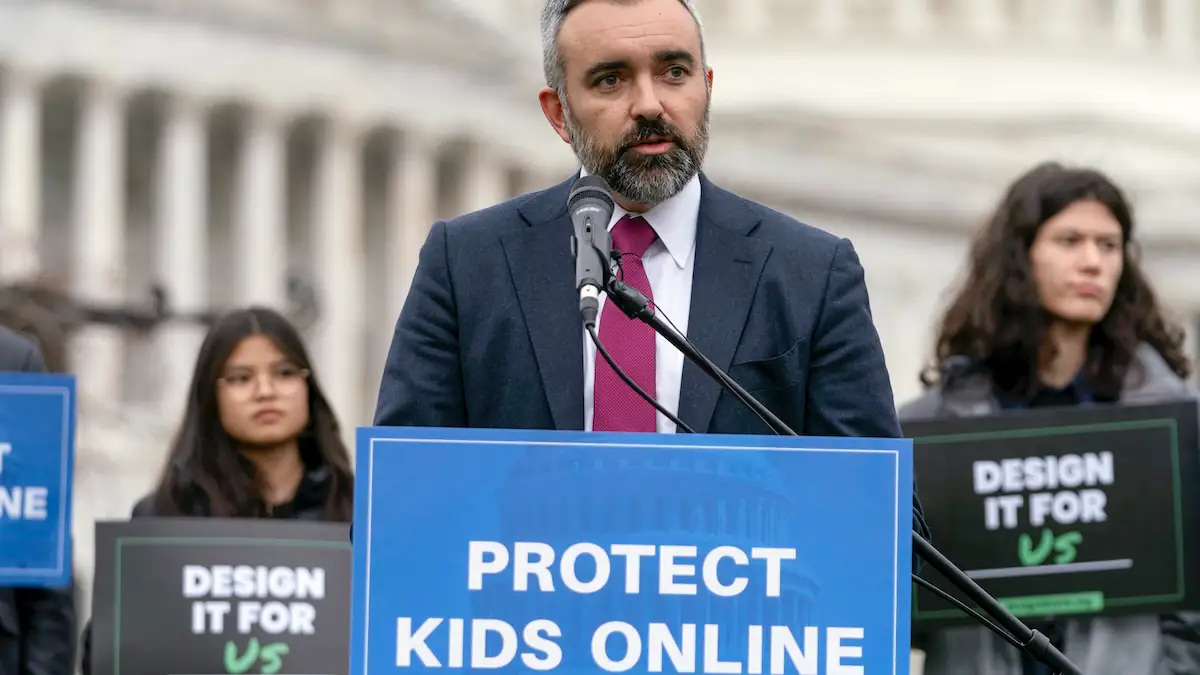  Raúl Torrez, Generalstaatsanwalt des Bundesstaates New Mexico, bei einer Rede, vor ihm ein Schild mit der Aufschrift „Protect Kids Online“