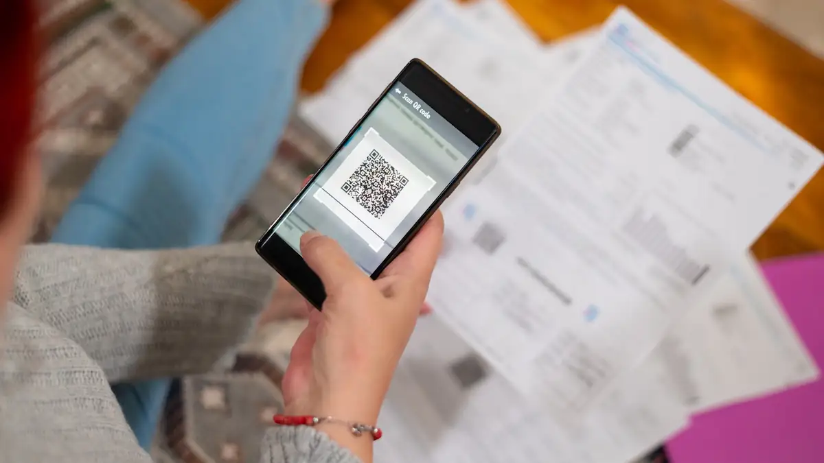 Frau scannt QR-Code von einem Dokument