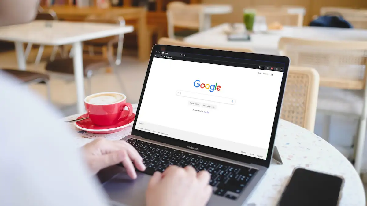 SEO Poisoning Symbolbild: Jemand benutzt die Google-Suche an einem Laptop