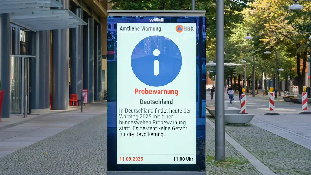 Infotafel an Bushaltestelle zeigt zum bundesweiten Warntag eine Warnung