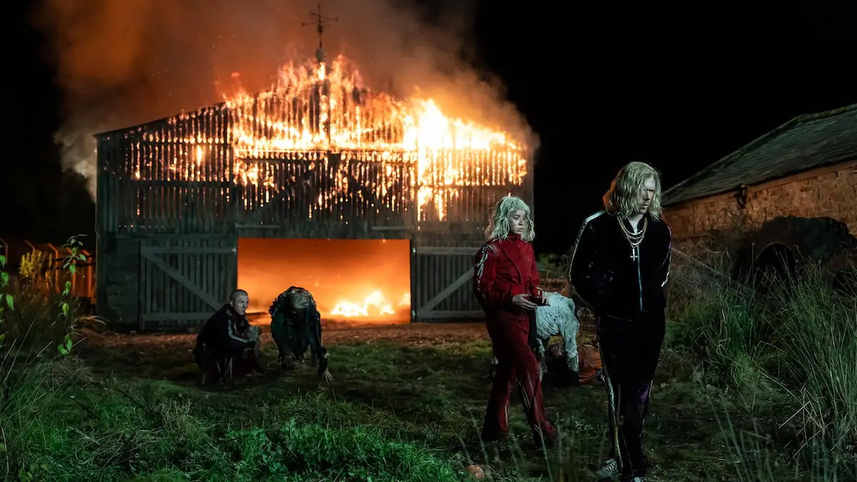Jack O Connell und Erin Kellyman vor einer brennenden Scheune in „28 Years Later: The Bone Temple“